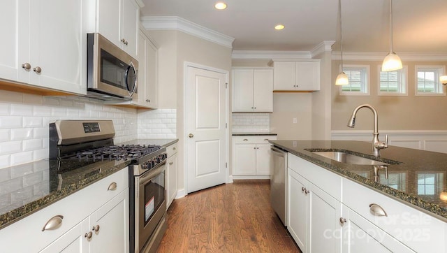 kitchen with white cabinetry, dark stone countertops, pendant lighting, and appliances with stainless steel finishes