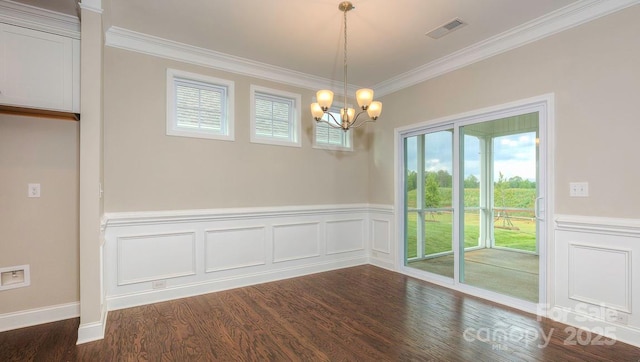 unfurnished dining area featuring dark wood-type flooring, crown molding, and a chandelier