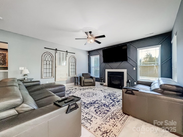 living room featuring ceiling fan and a barn door