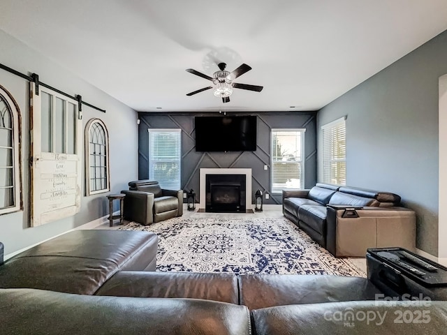 living room with ceiling fan and a barn door