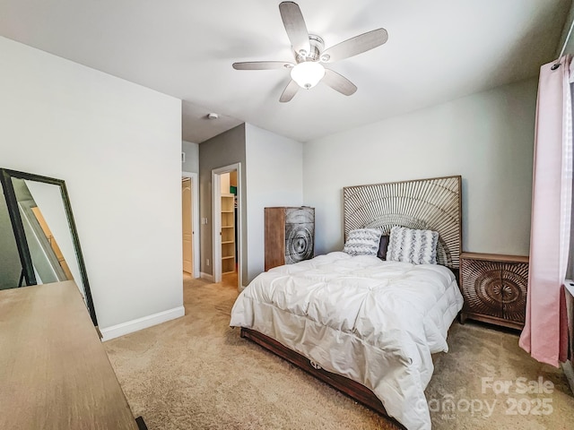 bedroom with ceiling fan, light colored carpet, a closet, and a spacious closet