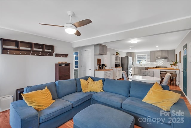 living room with ceiling fan and light wood-type flooring