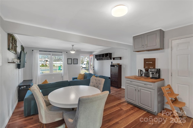 dining area with ceiling fan, dark hardwood / wood-style flooring, and ornamental molding