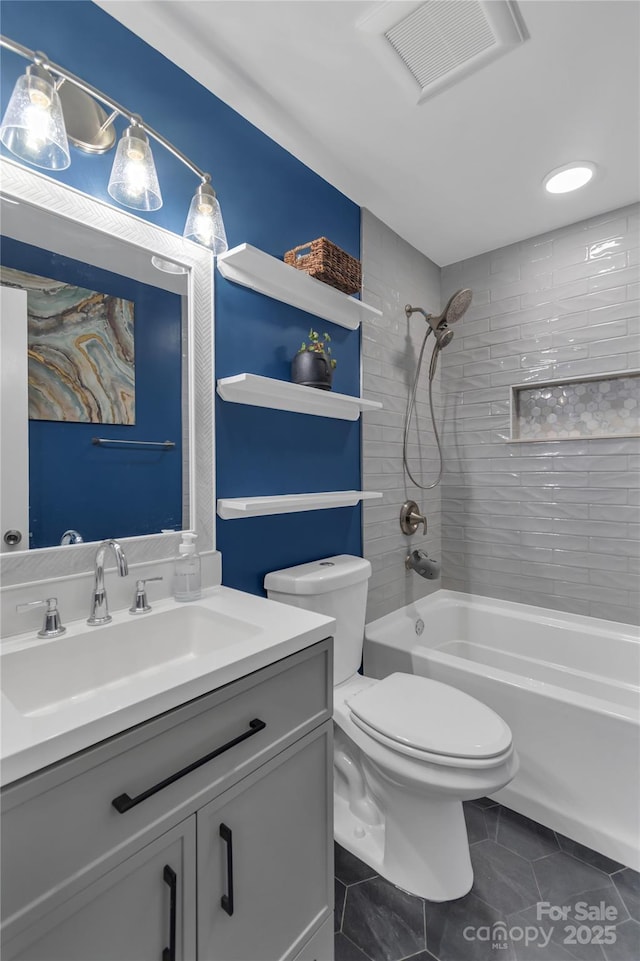 full bathroom featuring toilet, tiled shower / bath combo, vanity, and tile patterned floors