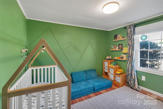 bedroom with ornamental molding and hardwood / wood-style flooring