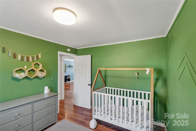 bedroom with dark hardwood / wood-style flooring and crown molding