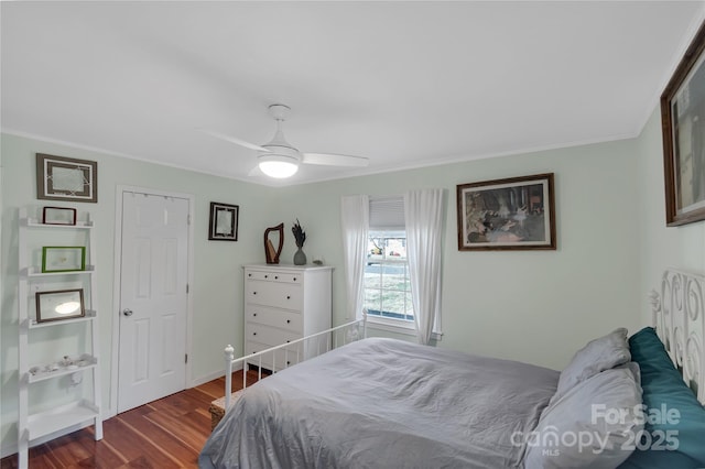 bedroom with dark wood-type flooring, ceiling fan, and crown molding