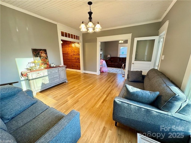 living room with crown molding, hardwood / wood-style flooring, and a chandelier