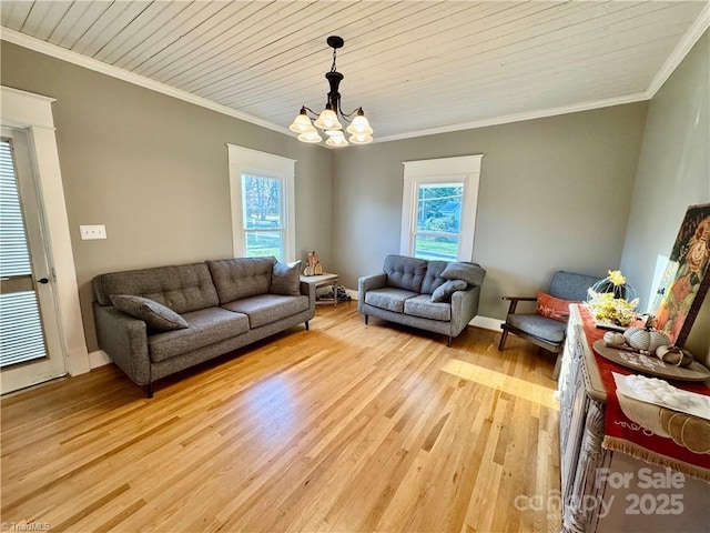 living room featuring light wood-type flooring, ornamental molding, and a notable chandelier