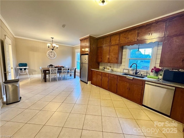 kitchen with crown molding, appliances with stainless steel finishes, hanging light fixtures, sink, and light tile patterned flooring