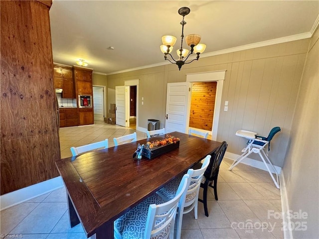 tiled dining room featuring wooden walls, a chandelier, and ornamental molding