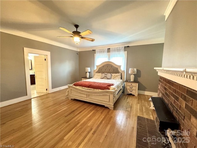 bedroom featuring ceiling fan, ensuite bathroom, light hardwood / wood-style flooring, and crown molding