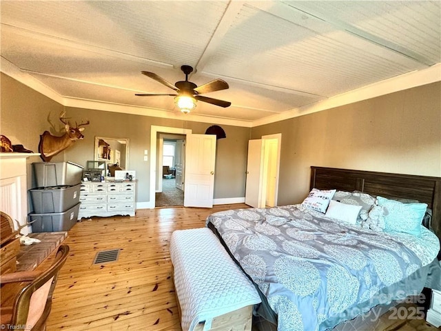 bedroom featuring crown molding, light wood-type flooring, and ceiling fan