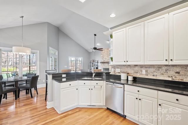 kitchen with white cabinets, stainless steel dishwasher, kitchen peninsula, and sink