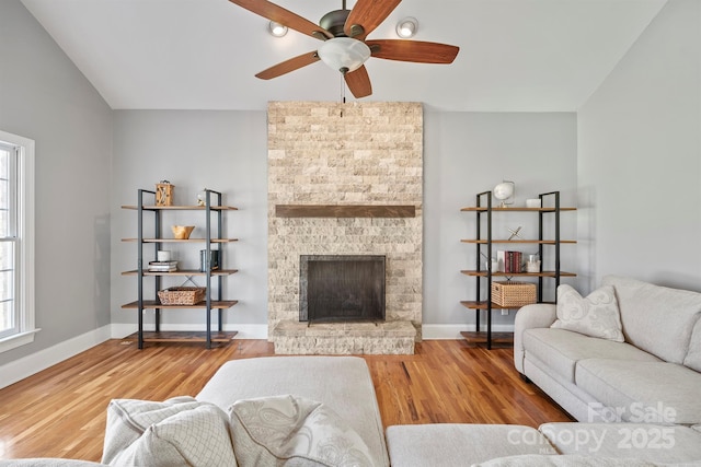 living room with ceiling fan, a fireplace, and hardwood / wood-style flooring