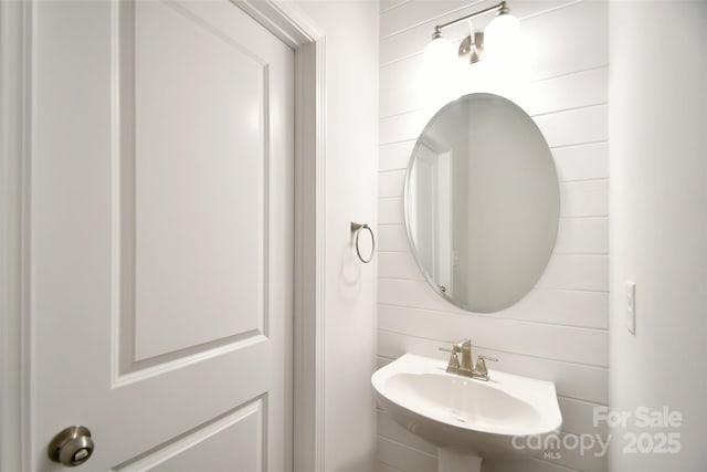 bathroom with sink and wood walls