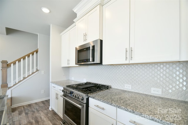 kitchen with white cabinetry, light stone counters, tasteful backsplash, dark hardwood / wood-style flooring, and appliances with stainless steel finishes