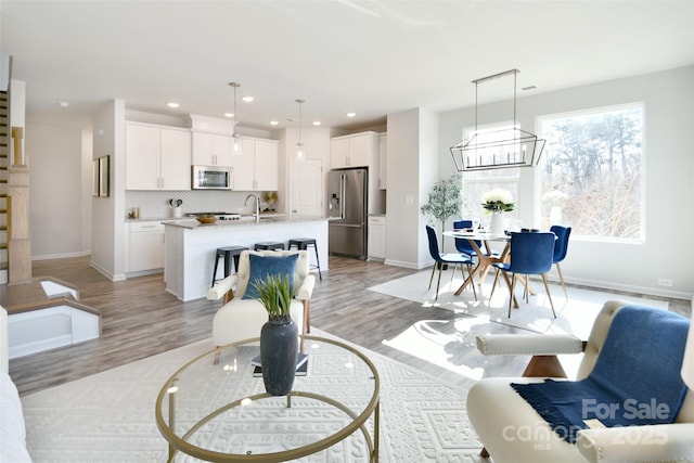 living room featuring sink and light hardwood / wood-style floors