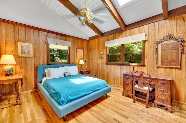 bedroom with ceiling fan, wood-type flooring, lofted ceiling with skylight, and multiple windows