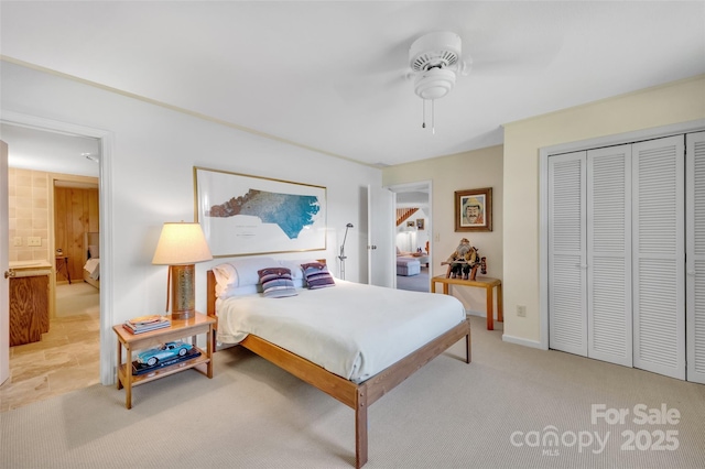 bedroom with ceiling fan, light colored carpet, and a closet