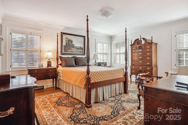 bedroom featuring hardwood / wood-style floors, crown molding, and multiple windows