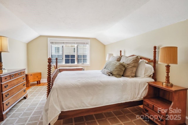 bedroom featuring a textured ceiling and lofted ceiling