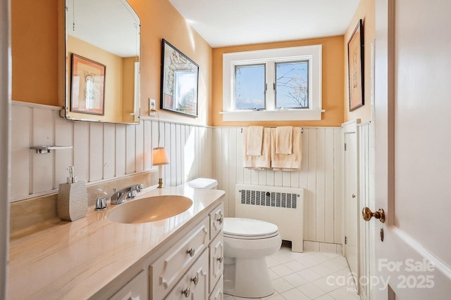 bathroom with vanity, toilet, radiator, and tile patterned flooring