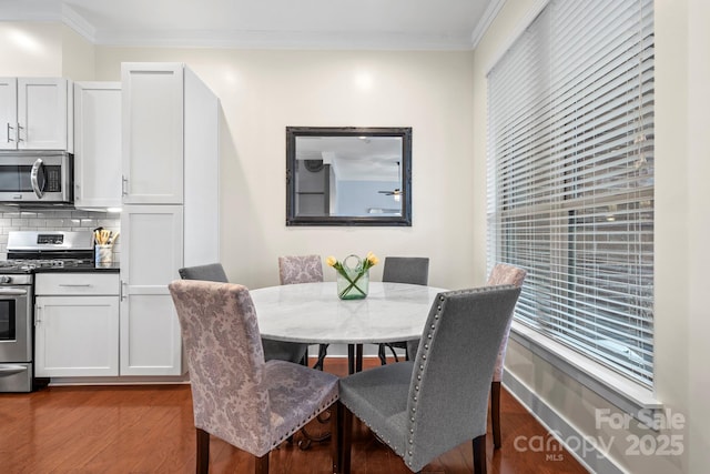 dining space with wood-type flooring and ornamental molding