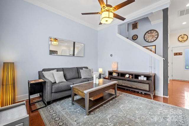 living room with ceiling fan, dark hardwood / wood-style flooring, and crown molding