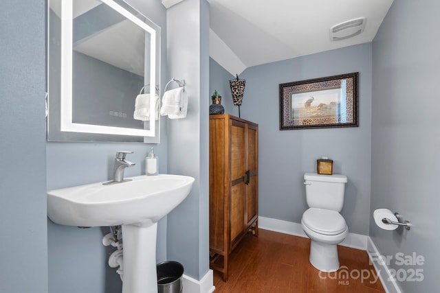 bathroom featuring toilet and wood-type flooring