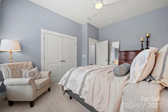 carpeted bedroom with ceiling fan and a closet