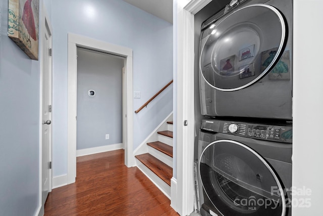 clothes washing area with stacked washer / dryer and dark hardwood / wood-style flooring