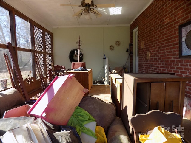 misc room with brick wall, ceiling fan, and ornamental molding