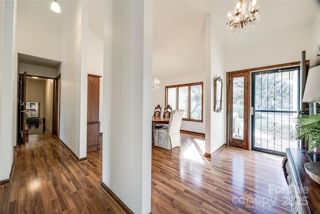 entrance foyer with a high ceiling, a notable chandelier, and dark hardwood / wood-style flooring