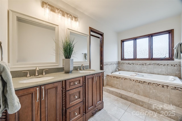 bathroom featuring tiled bath, tile patterned floors, and vanity