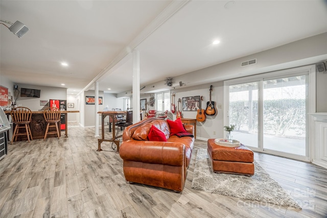 living room featuring light wood-type flooring and indoor bar