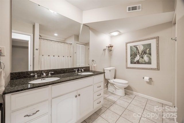 bathroom with toilet, tile patterned flooring, curtained shower, and vanity