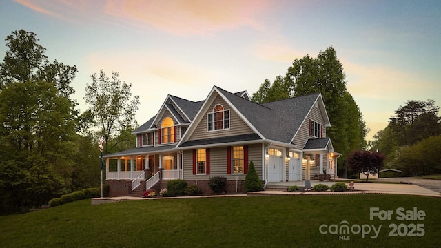 craftsman-style house featuring a garage, covered porch, and a yard