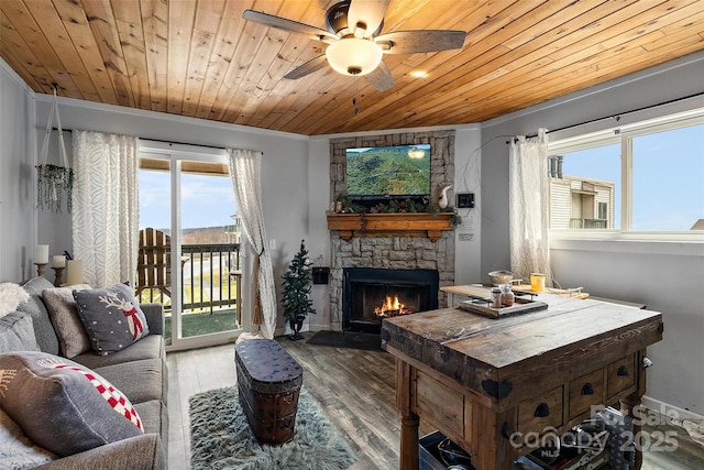 living room featuring wooden ceiling, ceiling fan, hardwood / wood-style flooring, and a stone fireplace