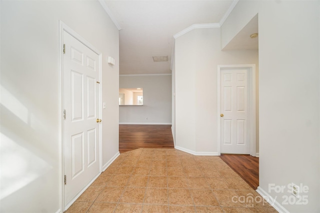 hallway featuring tile patterned floors, baseboards, and crown molding