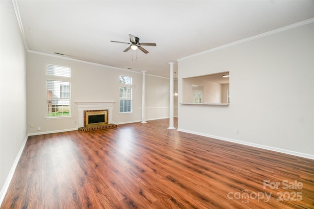 unfurnished living room with a ceiling fan, wood finished floors, baseboards, decorative columns, and a fireplace