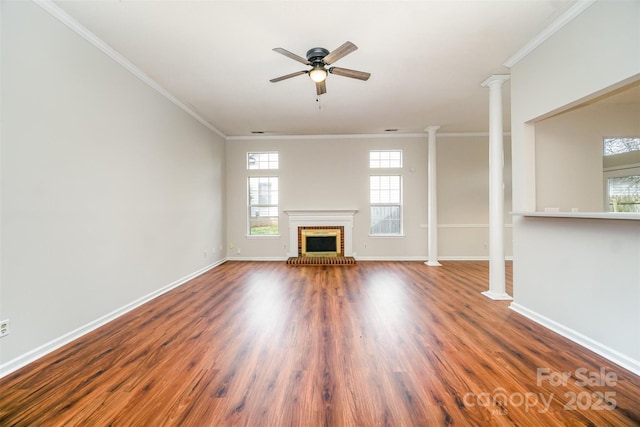 unfurnished living room featuring ornamental molding, wood finished floors, baseboards, and decorative columns