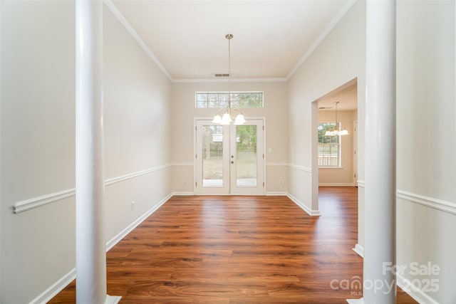 interior space featuring visible vents, a chandelier, dark wood finished floors, and ornamental molding