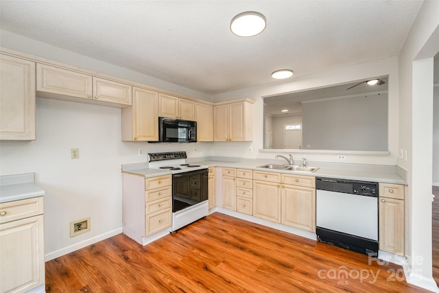 kitchen with cream cabinetry, black microwave, dishwasher, electric range, and a sink