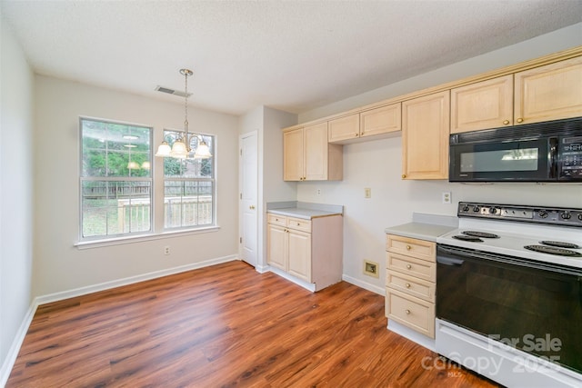 kitchen with wood finished floors, visible vents, light countertops, black microwave, and range with electric stovetop