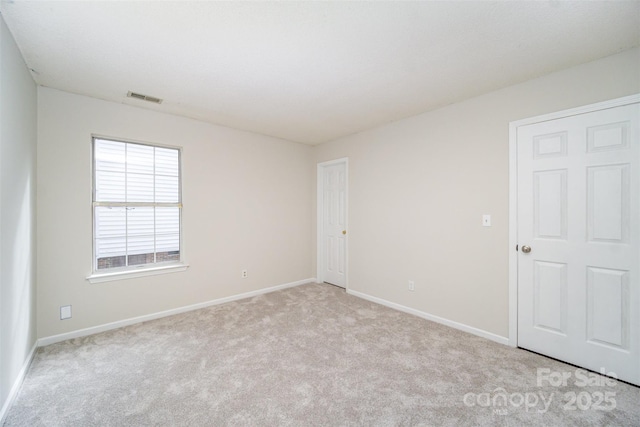 spare room featuring visible vents, carpet flooring, and baseboards