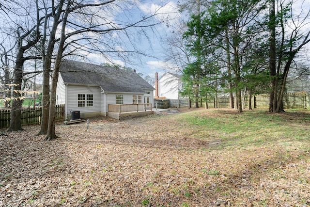 view of yard with a deck, a fenced backyard, and central AC