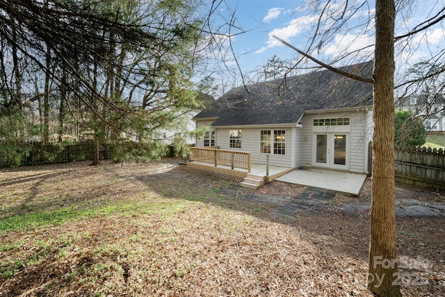 rear view of property with a patio area, french doors, a wooden deck, and a fenced backyard