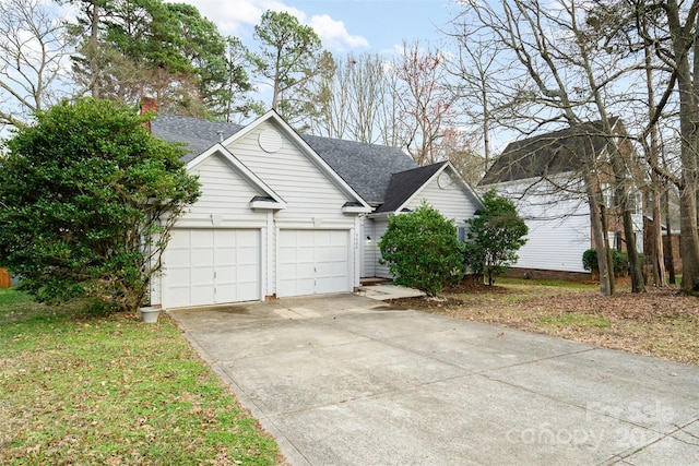 view of front of home with roof with shingles and driveway