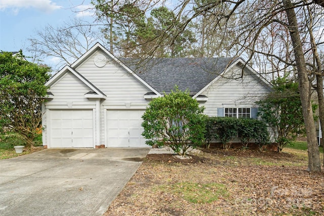 view of front of home featuring concrete driveway, an attached garage, and roof with shingles